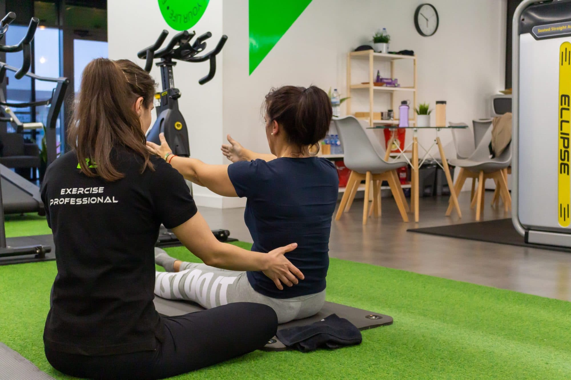 Sessão de pilates clínico, sentada, com a fisioterapeuta