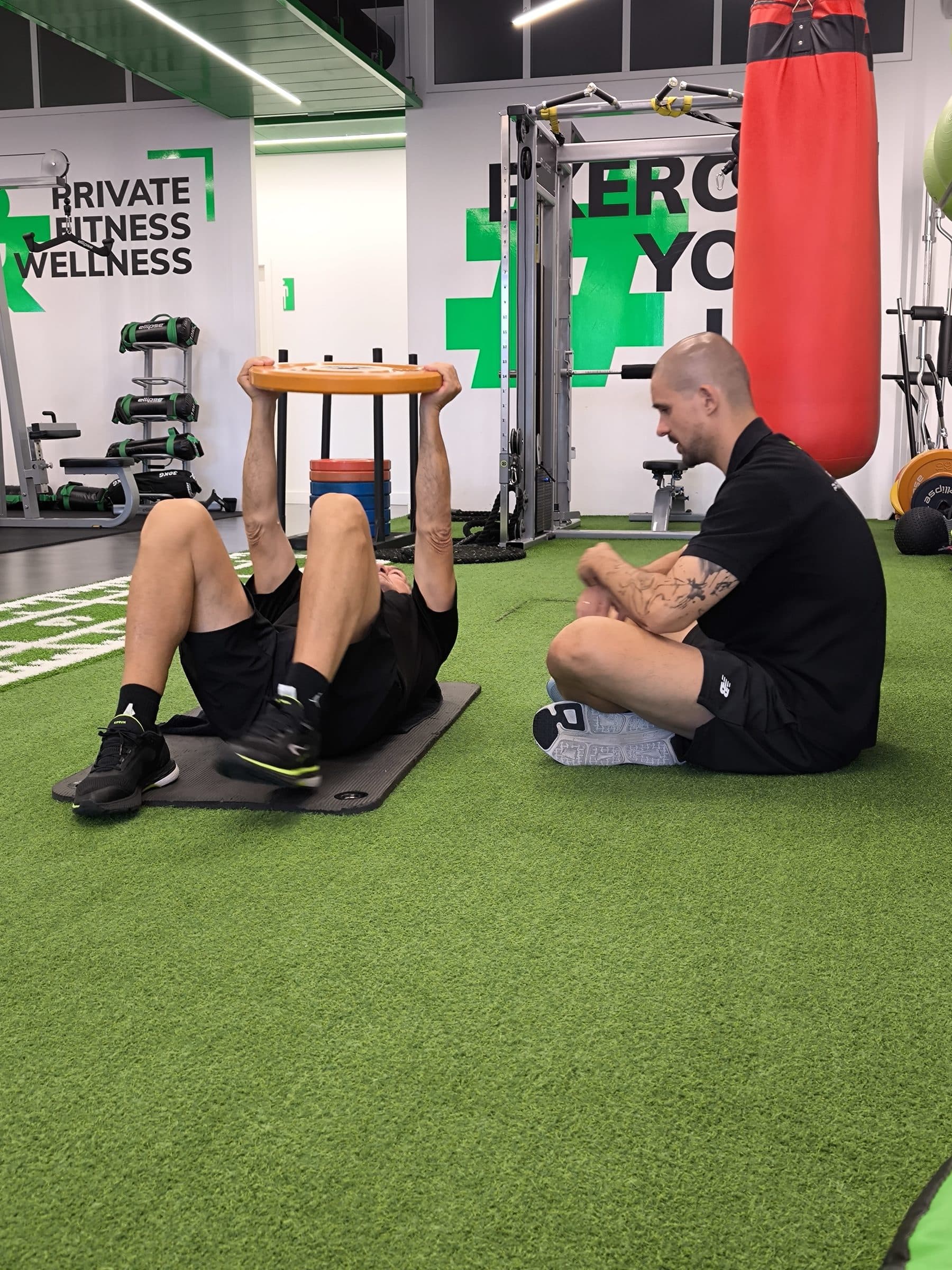 Sessão de reabilitação no BSPLACE, exercício no solo com o profissional ao lado